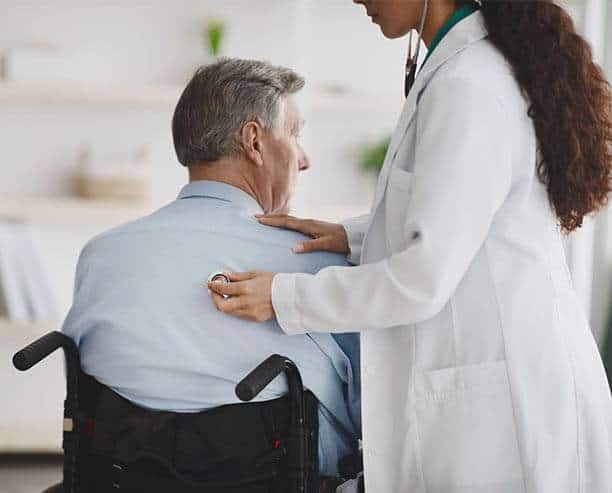 Nurse Pushing Man In Wheel Chair
