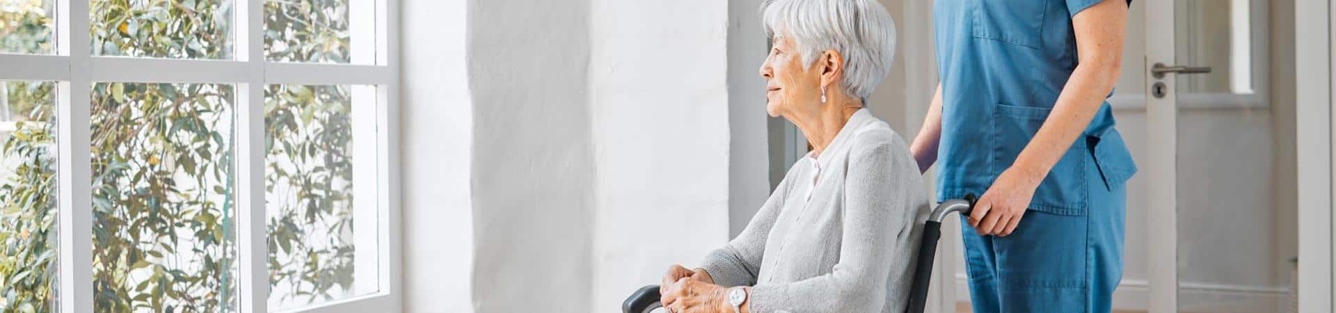 Woman In Wheelchair Looking Out Window