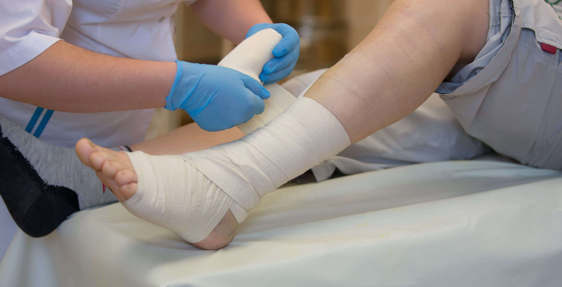Medical Professional Wrapping Bandage On Patient Leg