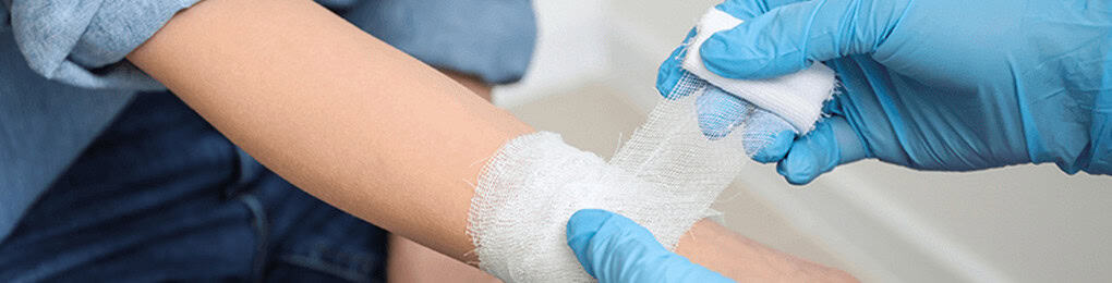 a wound care nurse wrapping a woman’s wrist in gauze